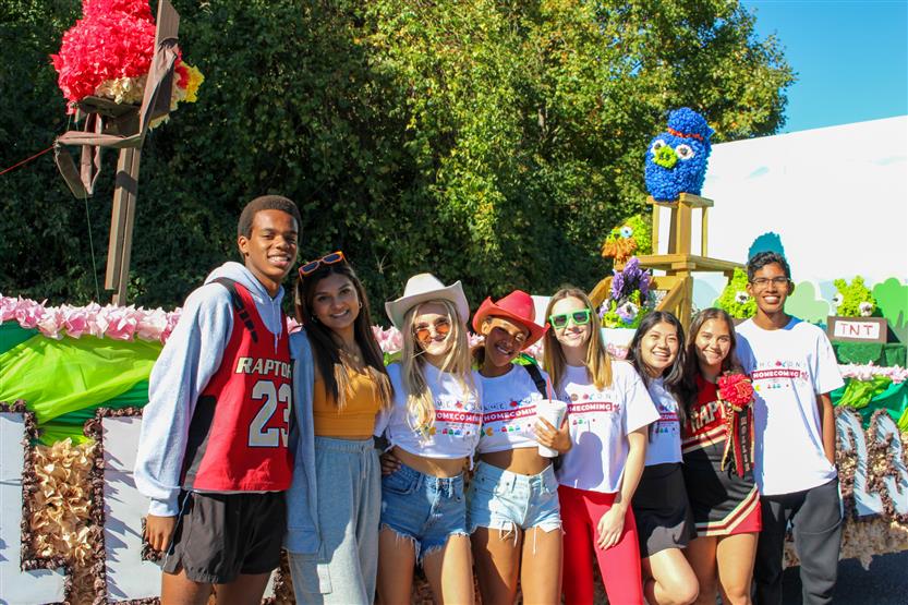 Students smile in front of an Angry Bird float